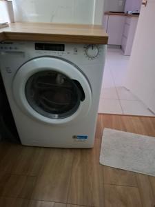 a white washing machine in a kitchen with a rug at Blue Mare Hebe Apartament in Łukęcin