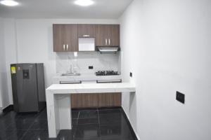 a kitchen with a white counter and a refrigerator at Santo Rio in Santa Marta