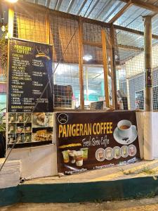 a sign for a pangwegian coffeeastery with a cup of coffee at Teresek View Motel in Kuala Tahan