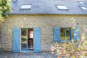 a brick house with blue doors and windows at Ker Forn By Nid 'Ouest in Plobannalec-Lesconil