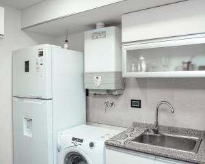 a kitchen with a white refrigerator and a washing machine at Departamento excelente vista.- in Comodoro Rivadavia