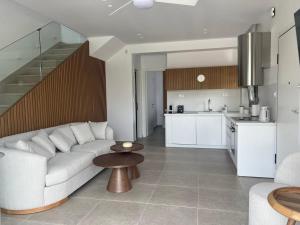 un soggiorno con un divano bianco e una cucina di Elia Luxury Villas by Eliamare a Nea Potidaea