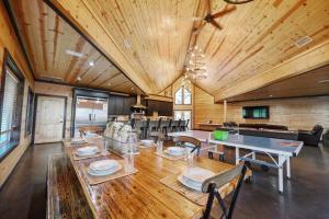 een grote eetkamer met een houten tafel en stoelen bij Big Timber Lodge in Broken Bow