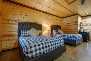 twee bedden in een kamer met houten wanden bij Big Timber Lodge in Broken Bow