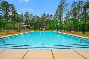 een zwembad met blauw water en een hek bij Big Timber Lodge in Broken Bow