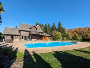 a house with a swimming pool in the yard at Lake views, spa, king bed, Golf Club amenities in Mont-Blanc