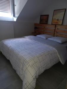 a bedroom with a bed with a blanket on it at Appartement-terrasse parking privé Meublé de Tourisme 4 étoiles in Belfort