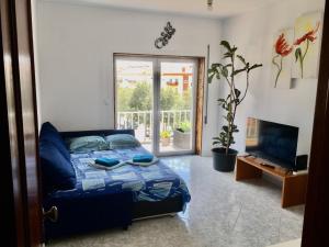 a bedroom with a bed and a tv and a window at CALIFORNIA dream in Peniche