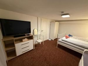 a hotel room with a flat screen tv and a bed at Family-friendly rental flat in Uetersen