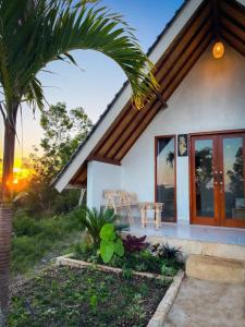 une maison avec un palmier devant dans l'établissement The Bluhu Hill Cottage, à Nusa Penida