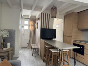 a kitchen with a table with a tv on it at Maison cosy, wifi terrasse, proche plage, gare, centre in Arcachon
