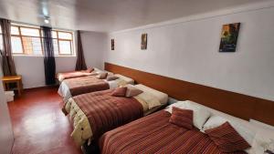 a room with three beds in a room at Magic Cusco in Cusco