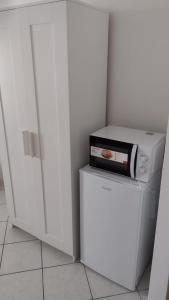 un frigorifero bianco con una scatola sopra di CasaYudi Monolocale con piscina ad Aprilia Marittima