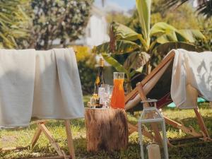 a table with bottles and glasses and a chair at Coastal Garden Paradise Retreat- 6 min from the beach in Charneca +15 photos