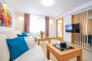 a living room with a white couch and a tv at 6BDR Home in Nature in Sarajevo