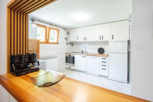a kitchen with white cabinets and a wooden counter top at 6BDR Home in Nature in Sarajevo