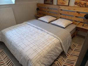 a bedroom with a large bed with a wooden headboard at Appartement-terrasse parking privé Meublé de Tourisme 4 étoiles in Belfort