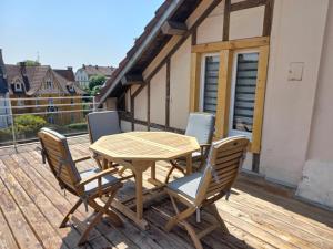 a wooden table and chairs on a deck at Appartement-terrasse parking privé Meublé de Tourisme 4 étoiles in Belfort