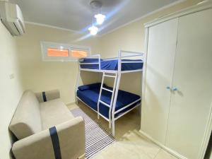 a small room with a bunk bed and a couch at Apartment in El Alamein,Sia Lagoon,Golf porto marina in El Alamein +6 photos