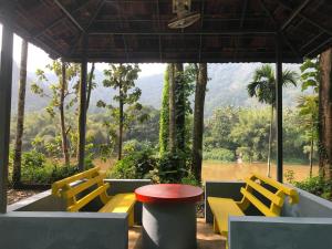a group of yellow chairs and a red table at Rainy Woods Inn in Neriyamangalam