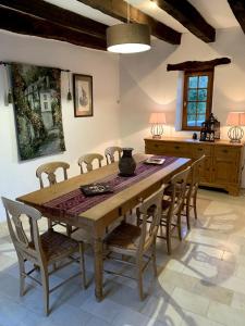 a dining room with a wooden table and chairs at Lovely family house in the middle of nature in Saint-Marcel-du-Périgord