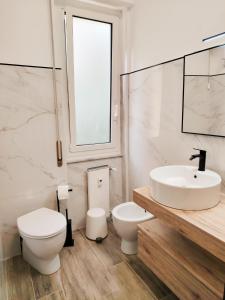 a white bathroom with a sink and a toilet at Genova Lux Apartment in Genova +39 photos
