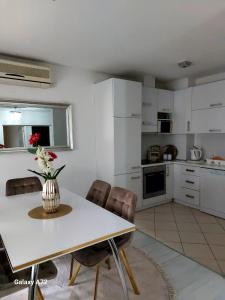 a kitchen with a table with a vase of flowers on it at Apartman River Una in Bihać +34 photos