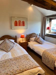 a bedroom with two beds and a window at Riding house Farm Cottages in Castleton
