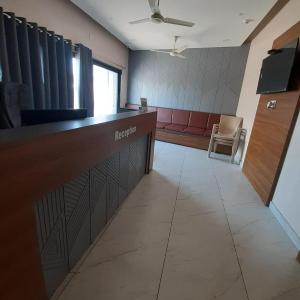 a waiting room with a reception desk and a chair at Hotel Purushottam in Dwarka +8 photos