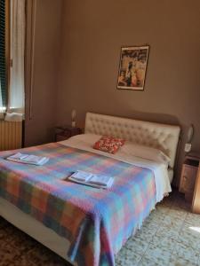 a bedroom with a bed with a colorful blanket at Albergo Montecatini in Montecatini Terme