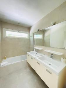 bagno con 2 lavandini, vasca e specchio di Le Domaine de la Montagnette a La Teste-de-Buch Altre 38 foto