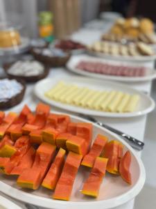 a table topped with plates of fruit and pastries at Pousada Laviê Morada de Leste in Pontal do Paraná