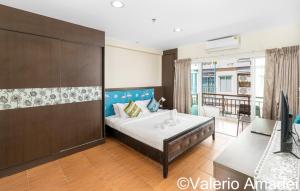 une chambre avec un lit, un bureau et une télévision dans l'établissement Phuket Villa Patong Beach by PHR, à Patong Beach 13 autres photos