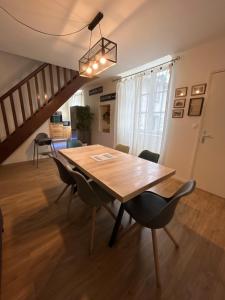 a dining room with a wooden table and chairs at Duplex T4 centre historique in Aurillac