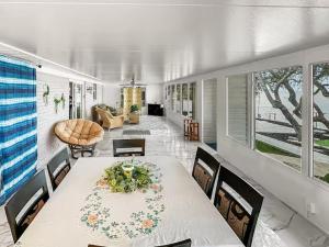 a dining room with a white table and chairs at Baywatch Paradice Bayfront, private pier, Sleeps 8 Fenced Dog Area 8 m to beach in Gulf Shores