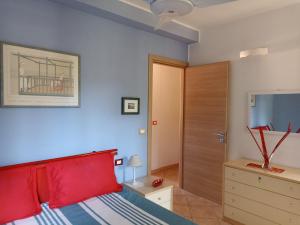 a bedroom with a red bed and a wooden door at La grande terrazza di Capo d'Arco in Capo D'Arco +26 photos