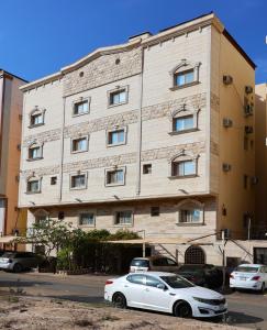 a white car parked in front of a building at Orchid Private Tourism Accommodation Facility اوركيد - لمرافق الضيافة السياحية الخاصة in Medina