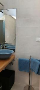a bathroom with a sink and a mirror and blue towels at Interno 5 Apartment in Lanciano +10 photos