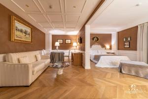 una camera d'albergo con un letto e un divano di Tesoretto Hotel a Poggiardo