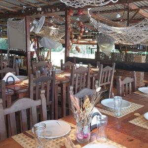 Un comedor con mesas y sillas de madera. en Cabañas Faro Delta, en Tigre
