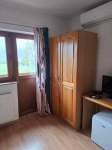 a room with a desk and a cabinet and a window at House Mara in Korenica