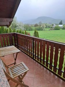 a wooden deck with a table and a bench at House Mara in Korenica