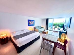 a bedroom with a bed and a table and a couch at Lounge modern chill studio Orient Bay in Orient Bay +66 photos