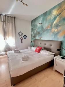 a bedroom with a large bed with a painting on the wall at Mia House Roma in Rome