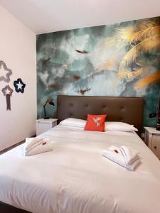 a bedroom with a large bed with a painting on the wall at Mia House Roma in Rome