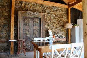 a dining room with a wooden table and white chairs at Pensiunea Agora in Cisnădioara