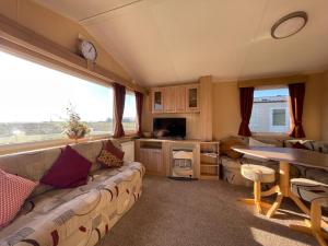 a living room with a couch and a table at Cambrian Rio Caravan in Ynys-lâs Station