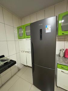 a black refrigerator in a kitchen with white cabinets at Toca da Onça in Coronel José Diaz