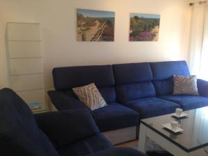 ein blaues Sofa im Wohnzimmer mit einem Tisch in der Unterkunft 3 BEDROOM LUXURY PENTHOUSE, BEACH, POOL, and GOLF, WIFI, Large TV SATELLITE,GARAGE in Vinarós