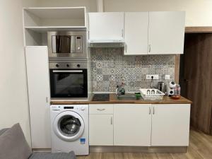 a kitchen with a washing machine and a microwave at PRADALONGO in Madrid
